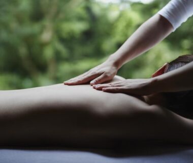Hands giving a back massage on a treatment table with green garden view at Hakone Retreat villa 1/f in Kanagawa