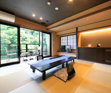 Tatami room with low table, shoji screens and balcony overlooking trees at Hakone Suimeisou, Kanagawa, Japan