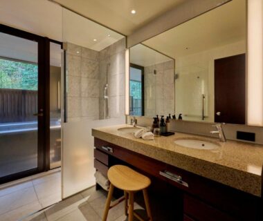 Double sink vanity and sliding door leading to outdoor wooden bath area at Hakone Suishoen, Kanagawa
