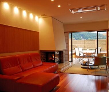Interior lounge with sofa, fireplace and balcony overlooking mountains at Hakone Tokinoshizuku in Kanagawa, Kantō