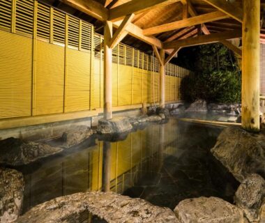 Covered rock-lined onsen with wooden pavilion at Hakone Yumoto Onsen Hotel Kajikaso, Kanagawa