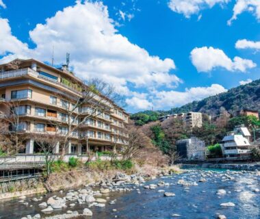 Riverside multi-story ryokan along rocky riverbank at Hakone Yumoto Onsen Hotel Kajikaso, Kanagawa, Kantō, Japan