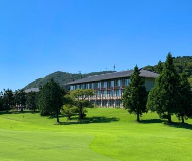 Expansive green lawns leading to Hakone Yunohana Prince Hotel with trees and hills in Kanagawa Japan