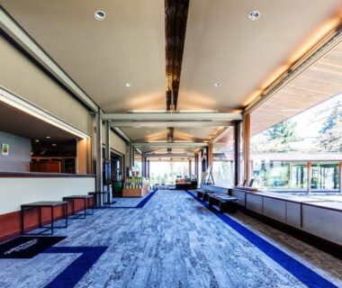 Long open lobby corridor with blue carpet, seating areas and floor-to-ceiling windows at Hakone Yunohana Prince Hotel Kanagawa