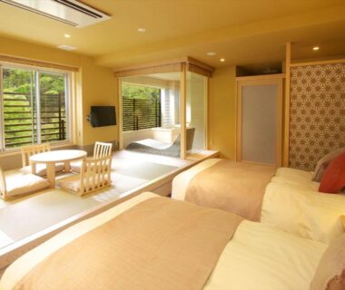 Tatami seating area with low table and two Western beds at Hakone Yuyado Zen in Kanagawa