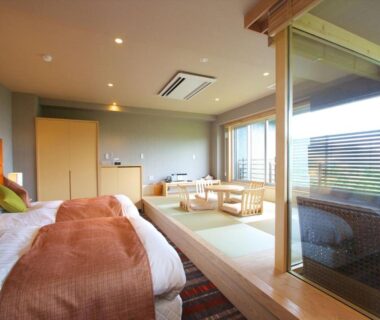 Spacious tatami room with two beds, low table seating and sliding glass door to balcony Hakone Kanagawa
