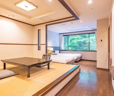 Raised tatami seating area with low table and twin beds at Hakoneji Kaiun, Kanagawa
