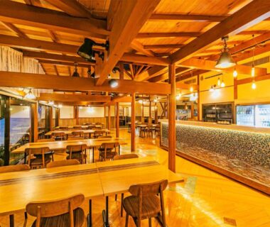 Spacious wooden dining hall with communal tables at Hakonenomori Okada Kanagawa