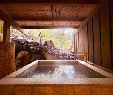 Stone onsen tub framed by wooden enclosure at Hakonesaryo Kintoki in Kanagawa