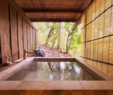 Stone-lined soaking bath with bamboo blinds and garden view at Hakonesaryo Kintoki, Kanagawa