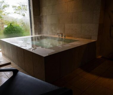 Steaming tiled indoor onsen bath with garden view at Haku Fuji Yamanakako, Yamanashi