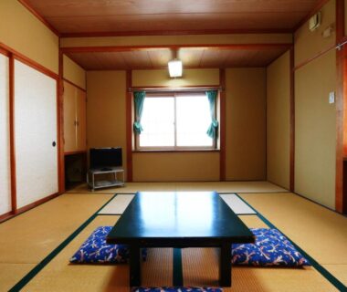 Traditional tatami room with low table, floor cushions, sliding doors and window at Hakuraiso, Nagano, Chūbu Japan