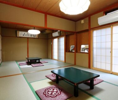 Tatami room with low tables and shoji screens at Hakuraiso, Nagano