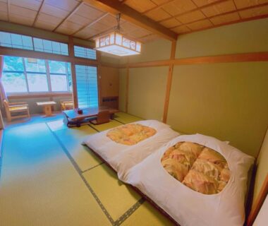 Tatami room with futon bedding, shoji screens and low table at Hakuunsou in Gifu, Chūbu
