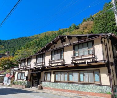 Two-story traditional ryokan building with balconies and mountain backdrop at Hakuunsou in Gifu Chūbu Japan