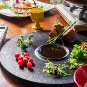 Assorted delicately plated small dishes and condiments on wooden table in Hakuunsou dining, Kanagawa, Japan