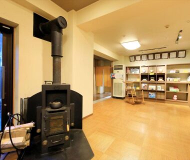 Ryokan lobby with wood stove, wooden floor and retail shelves, Hamabeno Ryouriyado Houraikan, Iwate