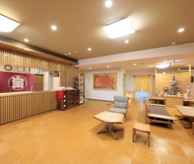 Reception lounge with wooden flooring, seating and traditional noren at Hamabeno Ryouriyado Houraikan, Iwate