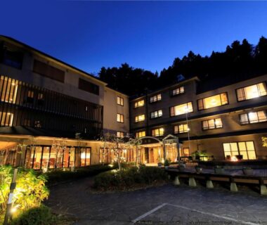 Night exterior of Hamabeno Ryouriyado Houraikan with lit courtyard and mountain backdrop in Iwate, Tōhoku