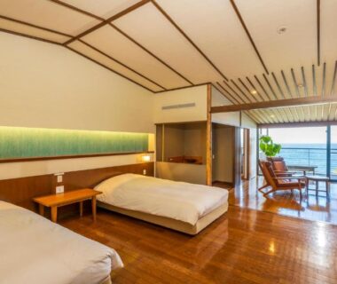 Modern twin room with wooden floors, bedside table and balcony at Hamachidorinoyu Kaisyu in Wakayama, Kansai