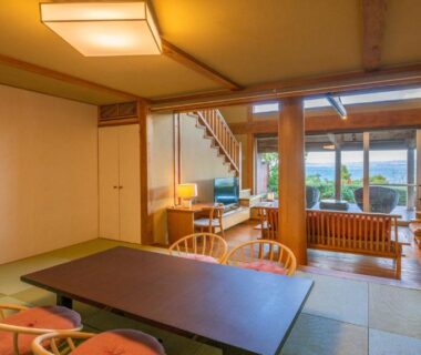 Traditional tatami room with low table, seating area and large windows at Hamachidorinoyu Kaisyu in Wakayama