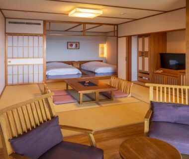 Traditional tatami room with futon beds, low table and shoji screens at Hamachidorinoyu Kaisyu in Wakayama