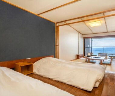 Twin bed room with tatami seating, shoji screens and balcony overlooking the sea at Hamachidorinoyu Kaisyu, Wakayama