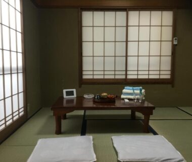 Traditional tatami room with low table, shoji screens, cushions and dining tray at Hamayuu, Shizuoka