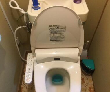 Compact Japanese bidet toilet with control panel and small tiled floor in Hamayuu, Shizuoka