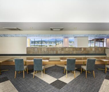 Lounge interior with chairs and bench seating by large window at Hana Irodori no Yado Kayuu in Wakayama