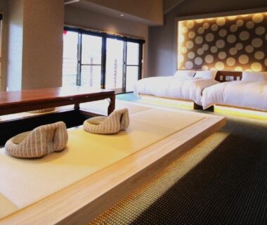Ryokan room with raised tatami area, floor cushions, twin beds and large windows at Hana No Shizuku Saga