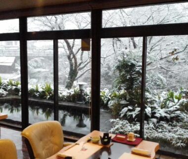 Seated dining area with tables and snow-covered garden visible through large windows at Hana No Shizuku, Saga, Kyushu