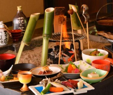 Assorted traditional Japanese dishes and lacquerware arranged around an irori hearth at Hana to Hana ryokan, Tochigi