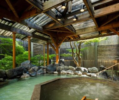 Wooden roofed onsen bath with stone edging at HanaMOMIJI, Hokkaidō