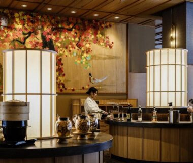 Staff preparing buffet in warm wooden dining area with lanterns and autumn mural at HanaMOMIJI Hokkaidō
