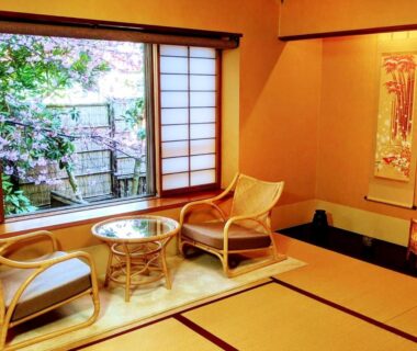 Tatami room with shoji window, rattan chairs, low glass table and garden view at Hanafubuki in Shizuoka