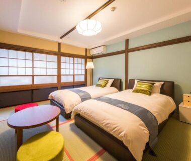 Traditional tatami room with shoji screens, twin beds, low table and cushions at Hanaingen in Gunma, Kantō