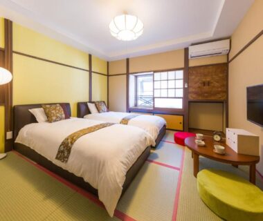 Bright tatami room with two beds, shoji window, low table and floor cushions at Hanaingen in Gunma