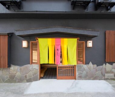 Yellow, pink and green noren above wooden lattice doorway at Hanaingen ryokan in Gunma, Kantō