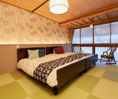 Tatami-floored room with two low beds and window seating at Hanakanzashi, Fukushima