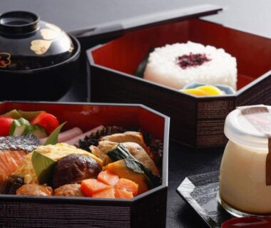 Lacquered bento boxes with rice, salmon, vegetables and dessert at Hanamandara in Hyōgo, Kansai