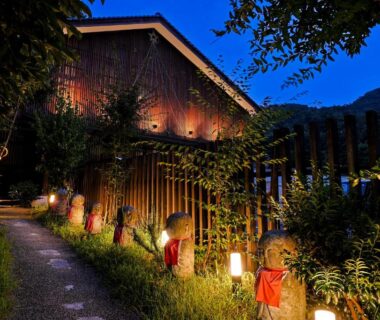 Evening lanterns and stone statues lining a garden path at Hanamandara in Hyōgo, Kansai, Japan