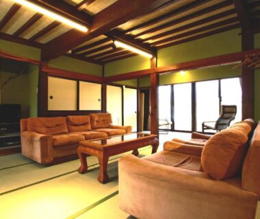Interior tatami lounge with sofas, low wooden table and sliding doors at Hanamizuki in Yamanashi, Chūbu