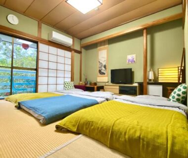 Traditional tatami room with futon bedding, shoji screens, low table and garden view at Hanamizuki Onsen Resort, Shizuoka