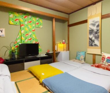 Tatami room with futon bedding, shoji screens, decorative kimono and tokonoma alcove at Hanamizuki Onsen Resort