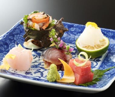 Delicately arranged sashimi with garnishes on a blue porcelain plate at Hananoyado Fukuya Kanagawa