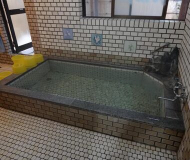 Small tiled onsen bath with faucets and tiled floor at Hanasaku Onsen Yoshiyaso, Gunma, Kantō
