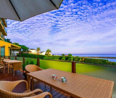 Wicker terrace seating with umbrella and glass railing overlooking the ocean at Hanashibuki, Chiba, Kantō