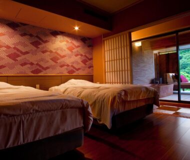 Twin bed room with shoji doors opening to wooden veranda bath and garden at Hanashinsui in Mie
