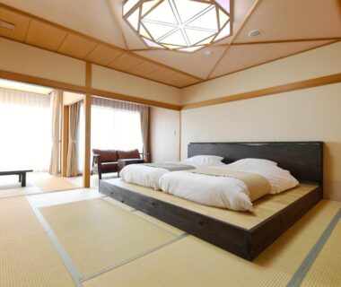 Spacious tatami room with low platform bed, shoji windows, wooden ceiling skylight at Hanasuishou in Yamanashi, Chūbu